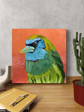 Barbie Barbet colourful bird artwork displayed on a wooden console beside a cactus
